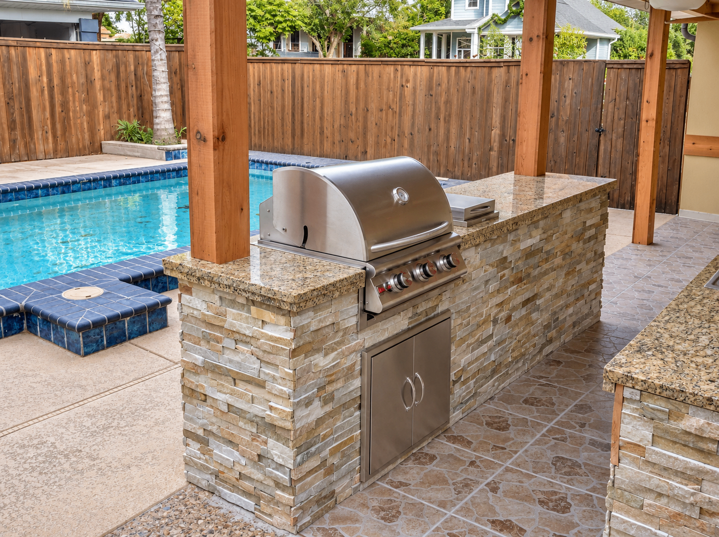 Built-in outdoor grill beside a swimming pool