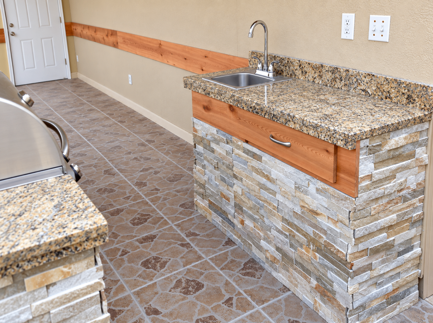 Outdoor kitchen sink and stone-clad counter